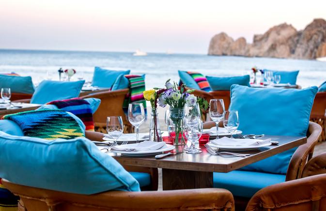 Chairs and tables set for dinner by the ocean