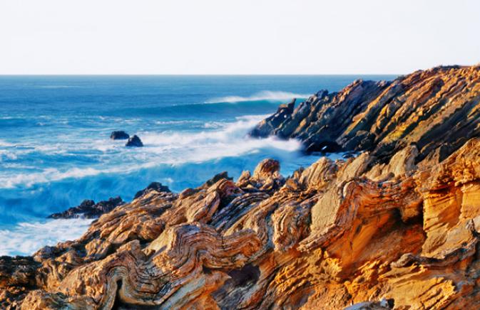 Lands end view of ocean waves crashing against rocky coastline