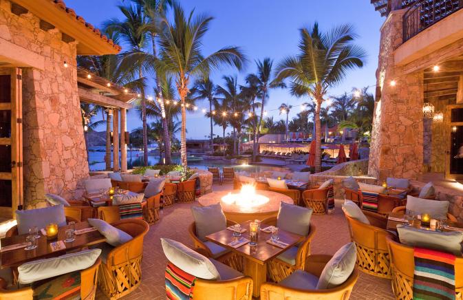 Chairs and tables set in the courtyard around a fire