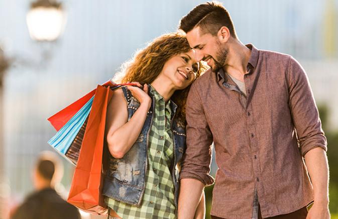 Couple walking hand in hand after a day of shopping 