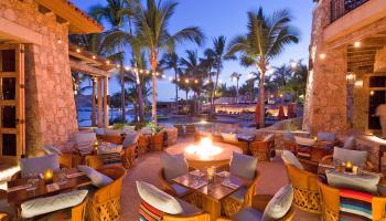 Chairs and tables set in the courtyard around a fire