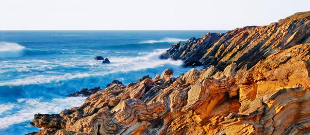 Lands end view of ocean waves crashing against rocky coastline